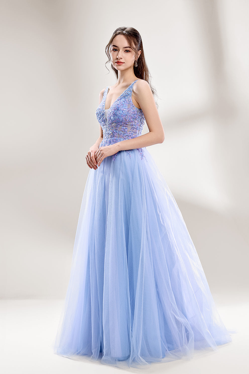 Bathed in soft light, a woman dazzles in a light blue tulle gown. It has a deep V - neckline with delicate lace embroidery on the bodice, and a flowing tulle skirt. The ethereal design creates a romantic and dreamy look, perfect for formal events like proms or weddings.4