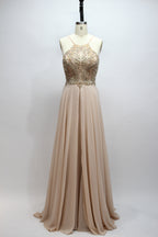 Photograph of a navy blue, floor-length, sleeveless gown on a dress form. The dress features intricate beadwork and sequin embellishments on the bodice, with a flowing, sheer skirt. The form is placed against a plain, light beige background, highlighting the dress's elegant, sophisticated design.9107-07