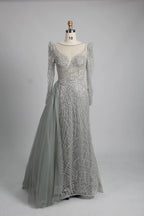 Silver long-sleeve mermaid gown with beaded lace texture and draped side overskirt