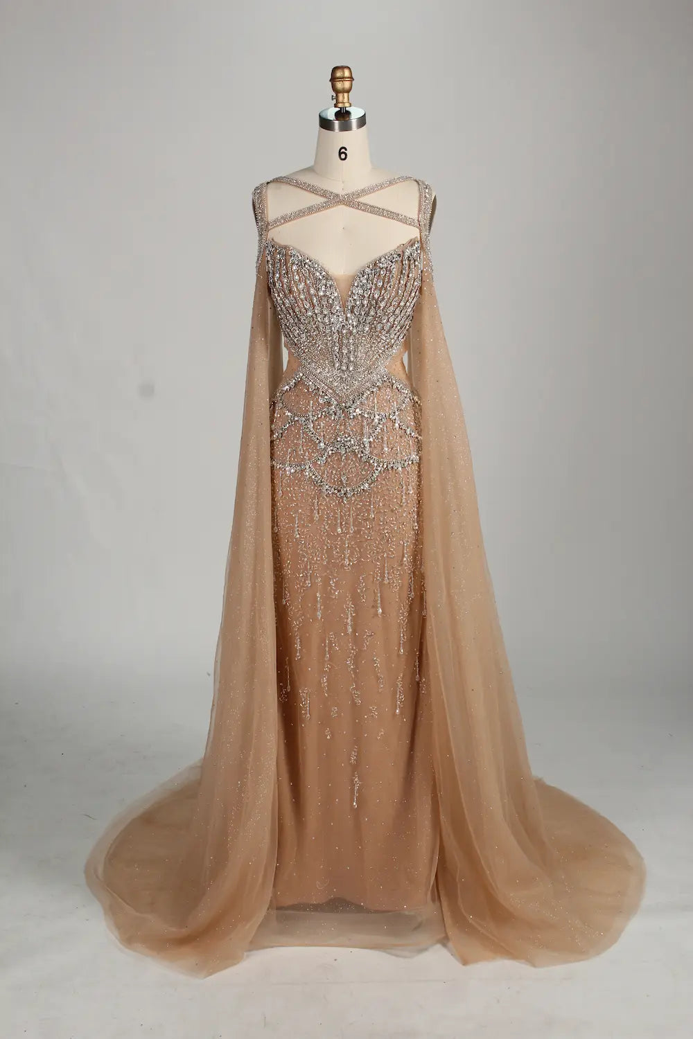 Front view: beaded halter champagne mermaid gown with draped sleeve capes
