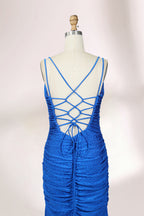 Photograph of a blue, floor-length evening gown displayed on a white dress form. The gown is sleeveless with a fitted bodice and a flared skirt, featuring thin shoulder straps and a textured, ruched design. The dress form is placed against a plain, off-white background, casting soft shadows.06