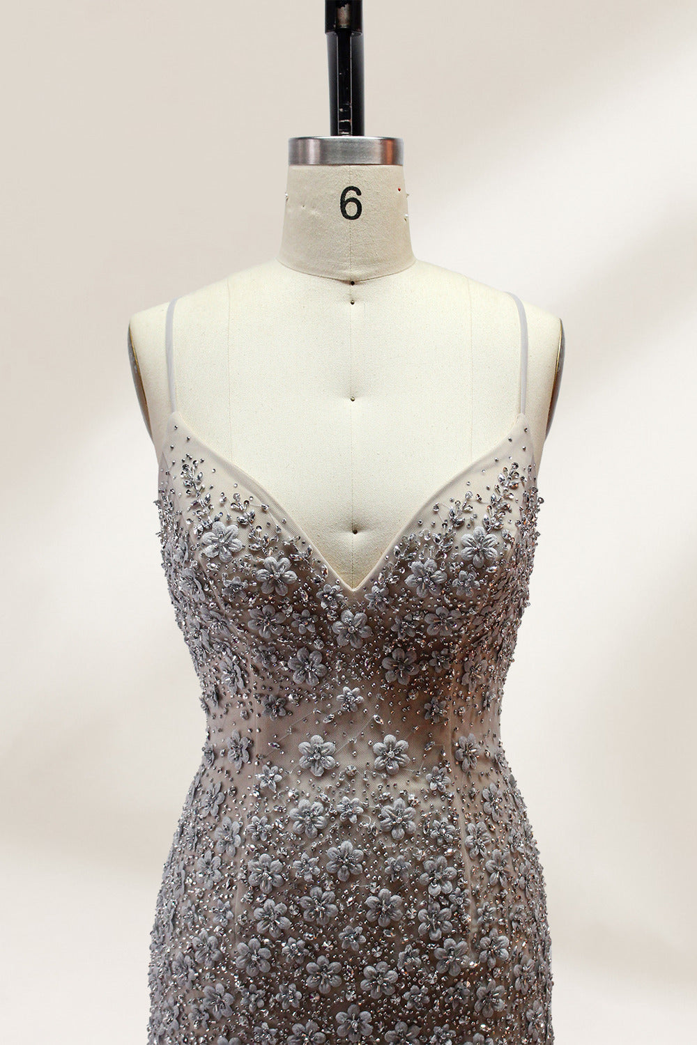 Displayed on a mannequin is a silver - gray mermaid - style gown. It features thin straps, a sweetheart neckline, intricate bead and sequin embroidery throughout, and a flowing tulle skirt. The elegant design creates a glamorous look, perfect for formal events like proms or weddings.4