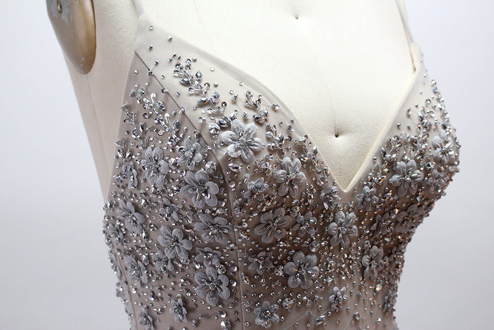 Displayed on a mannequin is a silver - gray mermaid - style gown. It features thin straps, a sweetheart neckline, intricate bead and sequin embroidery throughout, and a flowing tulle skirt. The elegant design creates a glamorous look, perfect for formal events like proms or weddings.6