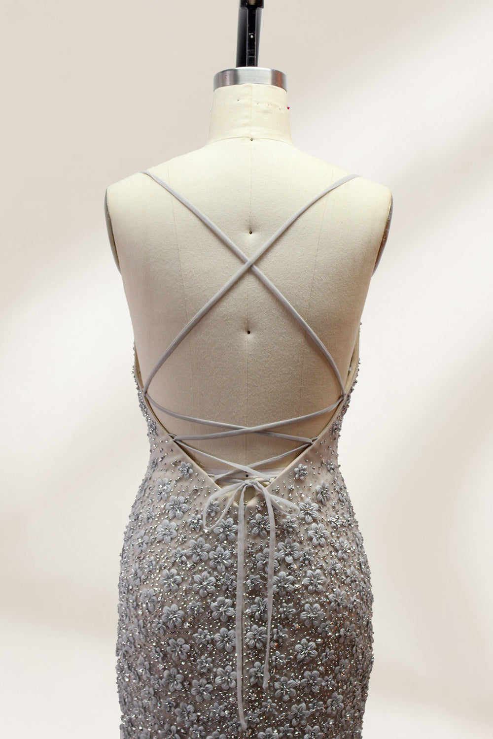 Displayed on a mannequin is a silver - gray mermaid - style gown. It features thin straps, a sweetheart neckline, intricate bead and sequin embroidery throughout, and a flowing tulle skirt. The elegant design creates a glamorous look, perfect for formal events like proms or weddings.5