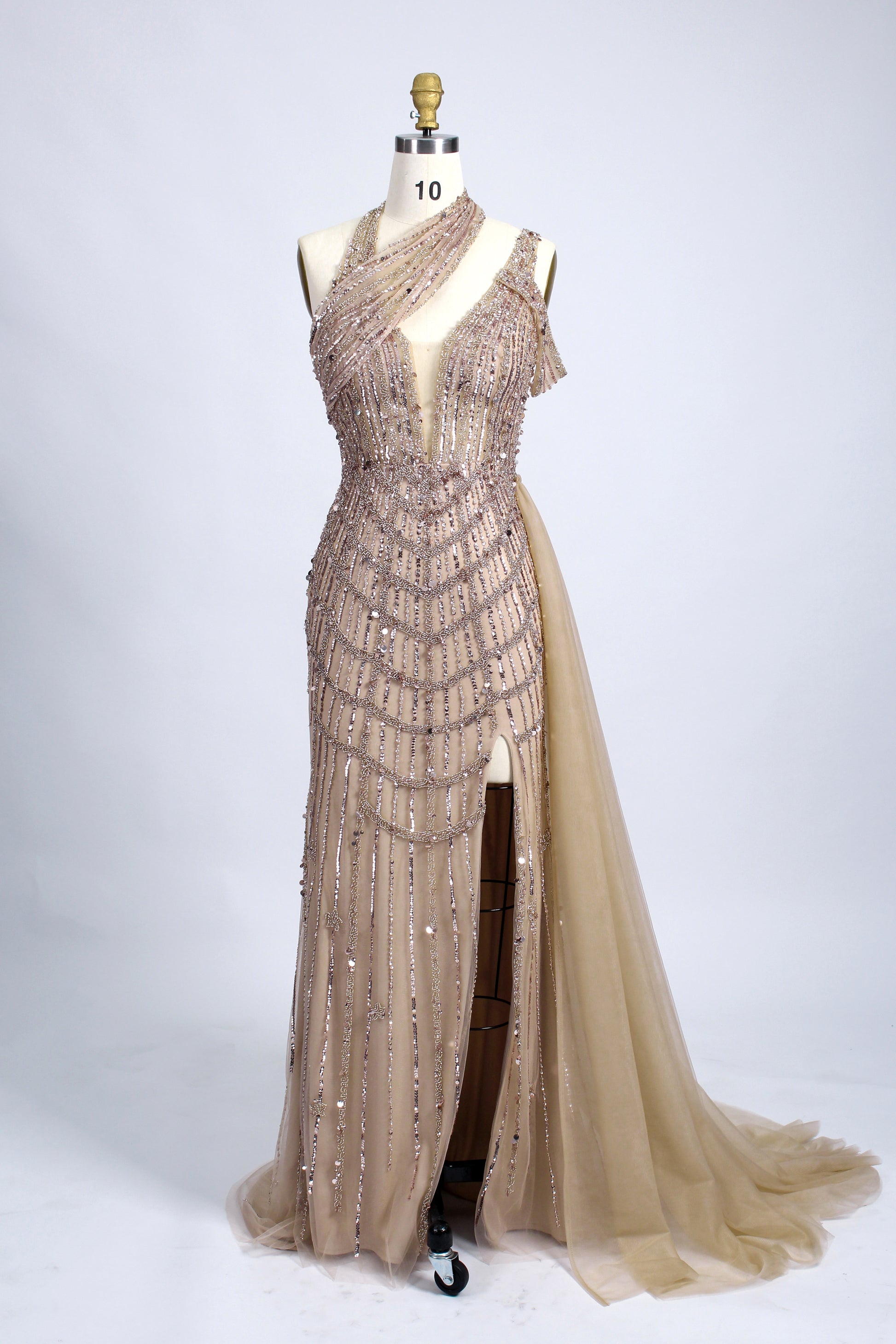 A woman with an elegant updo and a poised stance wears a teal, beaded gown. It has a high - neck, cut - out shoulder design, a form - fitting bodice, and a high side slit. A flowing tulle train adds drama. Paired with silver heels, it's perfect for formal events like galas, radiating glamour.7