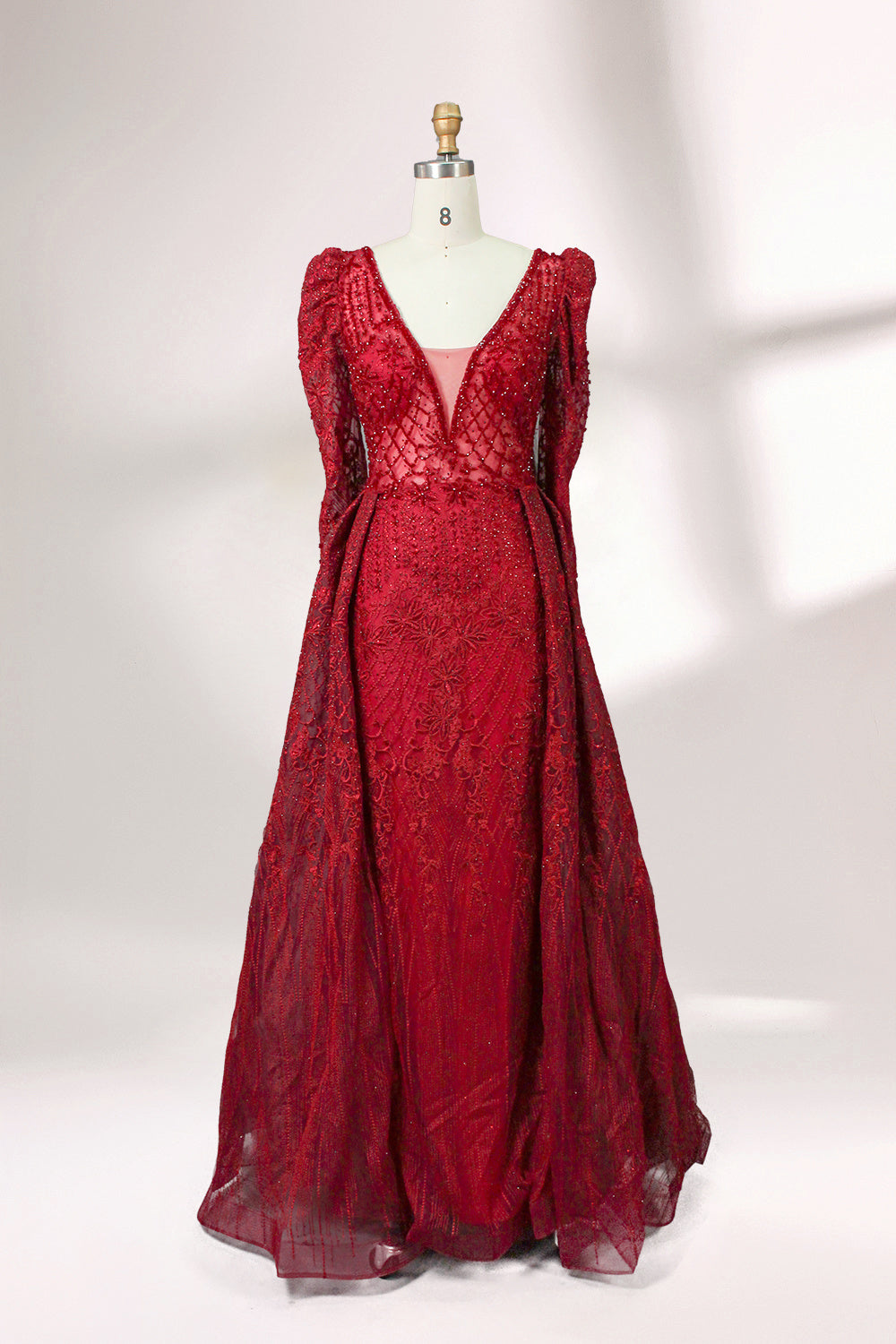 Illuminated softly, a mannequin showcases a light - gray evening gown. With a deep V - neckline, long puffed sleeves, and elaborate bead and lace embroidery, the gown exudes an air of luxury and sophistication, making it an excellent choice for formal galas and upscale events.5