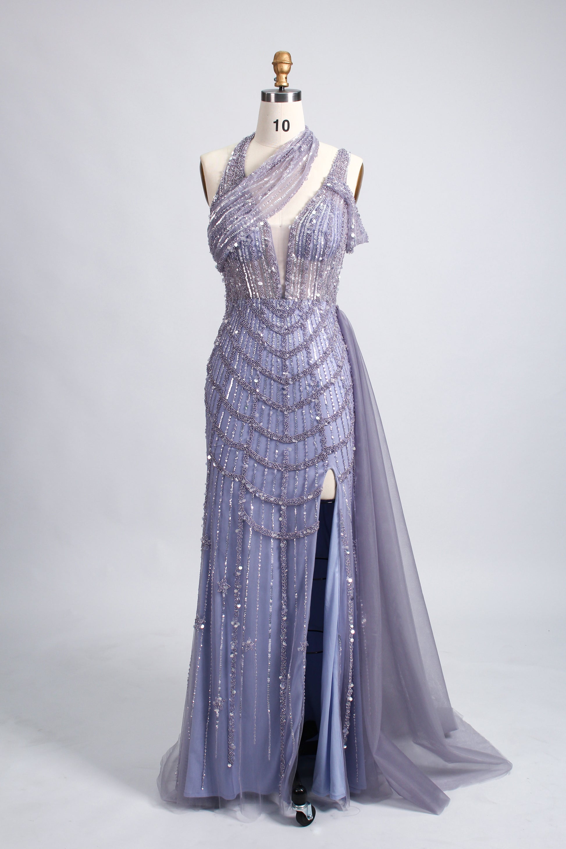 A woman with an elegant updo and a poised stance wears a teal, beaded gown. It has a high - neck, cut - out shoulder design, a form - fitting bodice, and a high side slit. A flowing tulle train adds drama. Paired with silver heels, it's perfect for formal events like galas, radiating glamour.8