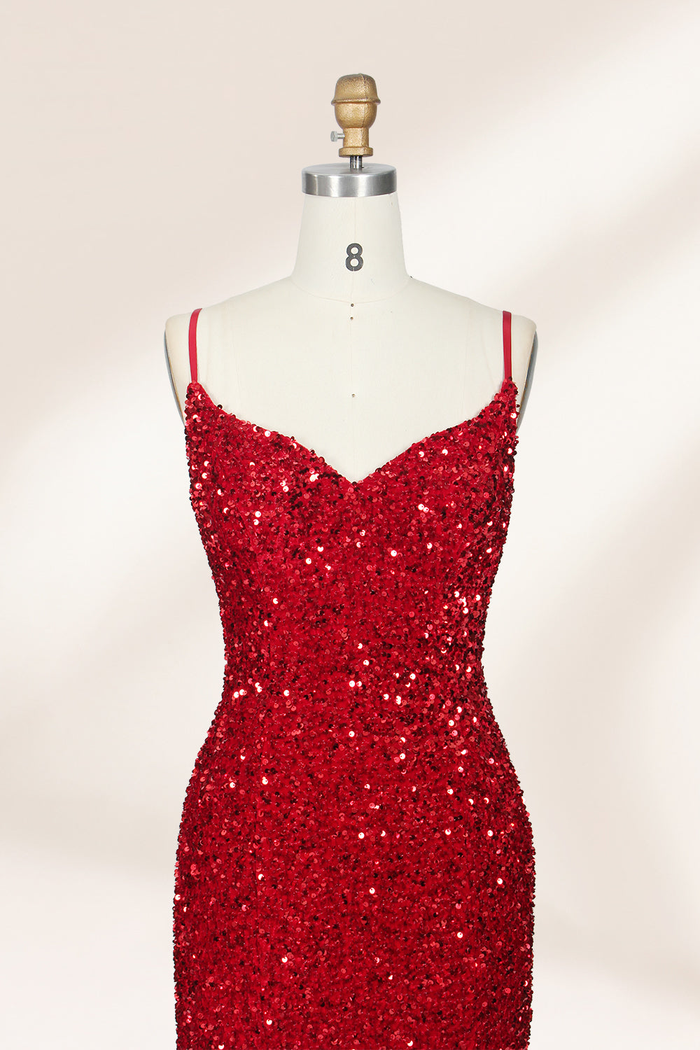 photograph of a mannequin wearing a red sequin evening gown, full-length, floor-length, sleeveless, V-neck, fitted bodice, flared skirt, glossy texture, elegant, glamorous, fashion, studio lighting, white background, soft shadows, high-end fashion, no accessories, no jewelry, no shoes, no face, no hair, no makeup, no background details, simple composition, focus on dress, no people, no textures, no patterns, no objects.04