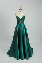 Bathed in soft light, a woman radiates elegance in a burgundy evening gown. With satin fabric, spaghetti straps, and lace embroidery, it crafts a luxurious and refined look for formal events.7