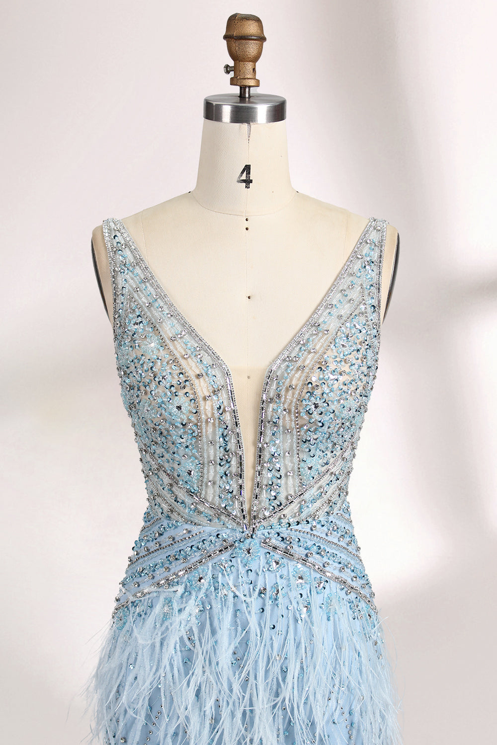 In soft lighting, a woman dazzles in a blue evening gown. With feather details, sequin embellishments, and a mermaid silhouette, it creates a luxurious and eye - catching look for formal events.5