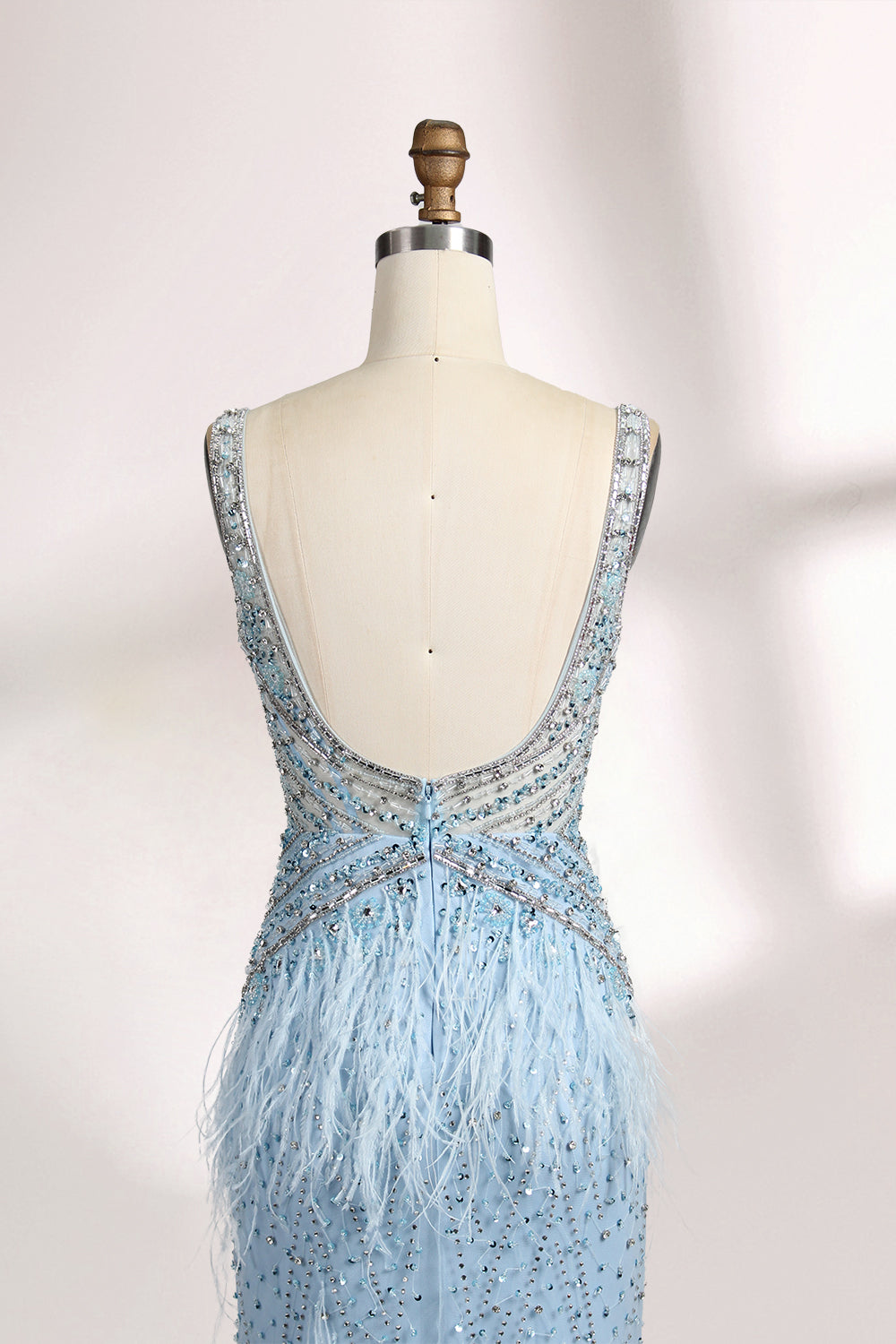 In soft lighting, a woman dazzles in a blue evening gown. With feather details, sequin embellishments, and a mermaid silhouette, it creates a luxurious and eye - catching look for formal events.56