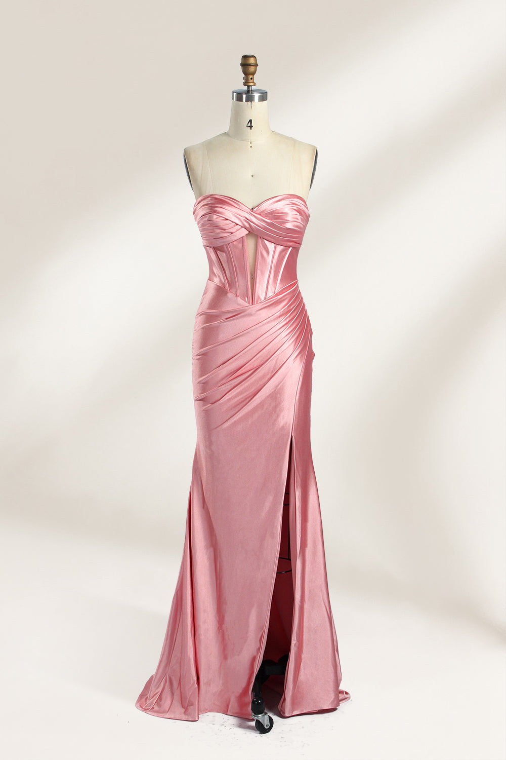 Against a gentle, light - colored backdrop, a mannequin showcases a strapless pink satin gown. The bust flaunts a twisted design, with a sheer insert at the bodice, and the waist is adorned with ruching. The mermaid - style skirt, featuring a high side slit, radiates elegance, perfect for formal galas.1