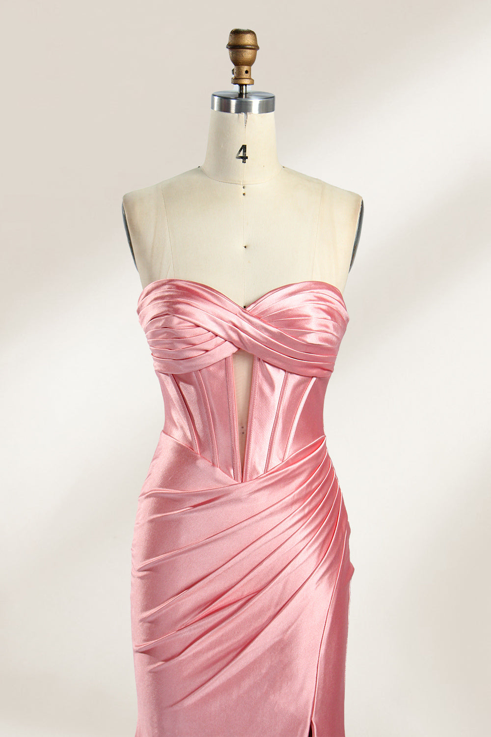 Against a gentle, light - colored backdrop, a mannequin showcases a strapless pink satin gown. The bust flaunts a twisted design, with a sheer insert at the bodice, and the waist is adorned with ruching. The mermaid - style skirt, featuring a high side slit, radiates elegance, perfect for formal galas.3