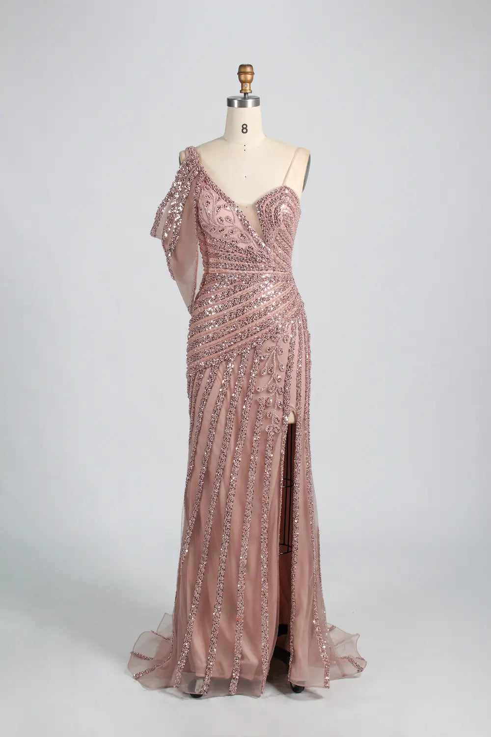 Pink one-shoulder beaded gown with lace-like texture and long sheer hem