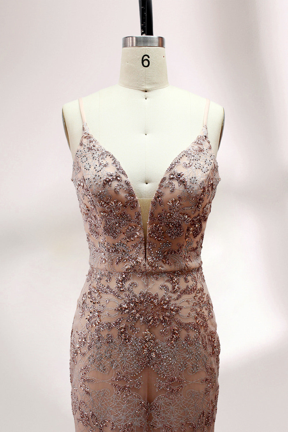 Presented on a mannequin is a blush - hued mermaid - cut gown. It features thin straps, a deep V - neckline, and is adorned with elaborate lace embroidery and sparkling accents. The sophisticated design exudes a glamorous and romantic charm, ideal for formal occasions such as proms or weddings.4