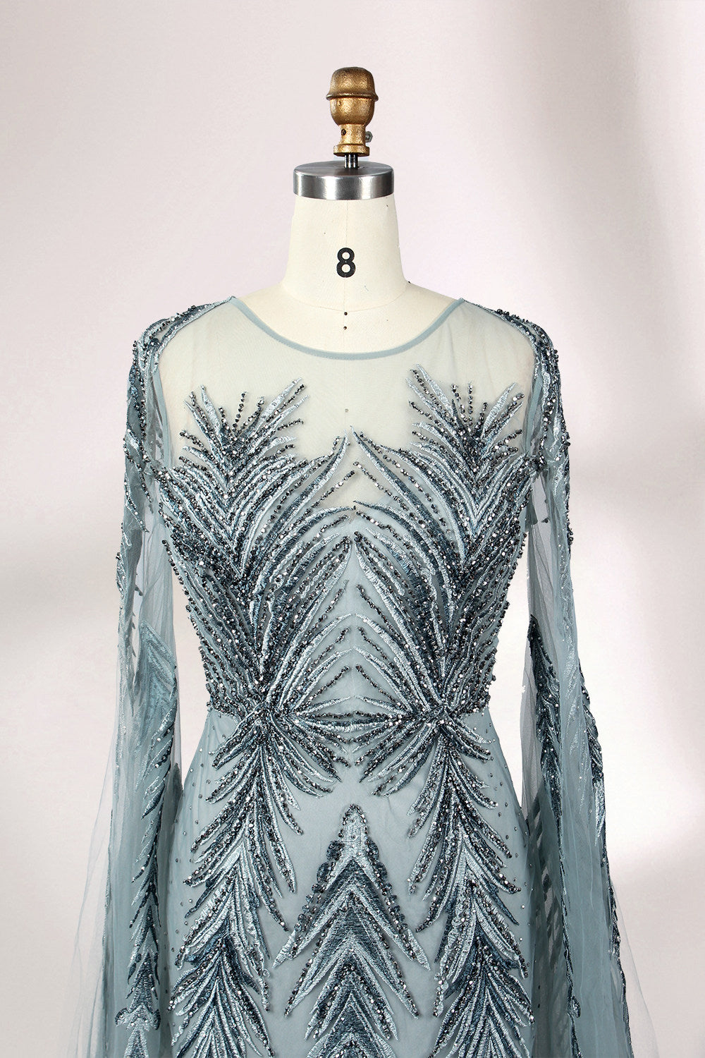 Showcased on a mannequin is a light - teal evening gown. It features a sheer high - neck design, long flowing sleeves, and intricate leaf - pattern embroidery. The gown's elegant and unique design exudes a sense of sophistication and grace, making it an ideal choice for formal events.
3