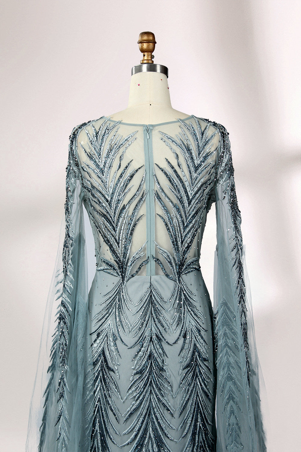 Showcased on a mannequin is a light - teal evening gown. It features a sheer high - neck design, long flowing sleeves, and intricate leaf - pattern embroidery. The gown's elegant and unique design exudes a sense of sophistication and grace, making it an ideal choice for formal events.
6