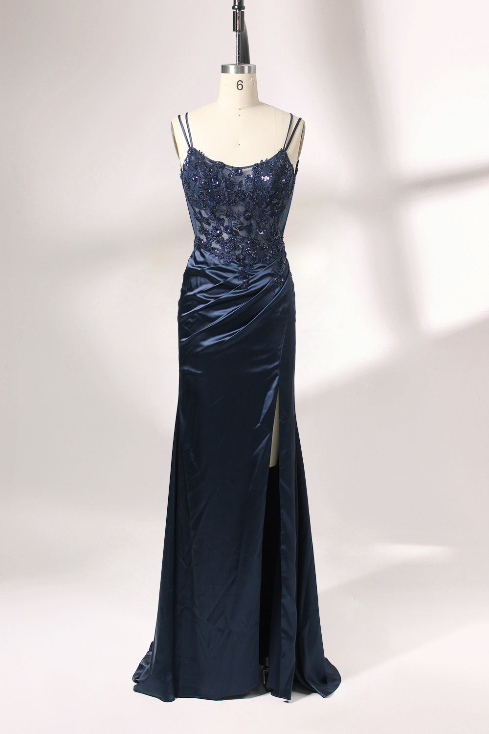 This is a floor - length evening dress in a deep navy hue. It has a strapless style with thin shoulder straps. The bodice is embellished with delicate beadwork and embroidery, creating an elegant and glamorous look. The skirt is form - fitting around the hips and flows down to the floor, featuring a side slit that adds allure and allows for easy movement. Displayed on a mannequin against a simple, light - colored backdrop, the dress exudes sophistication, perfect for special occasions like galas or proms.01