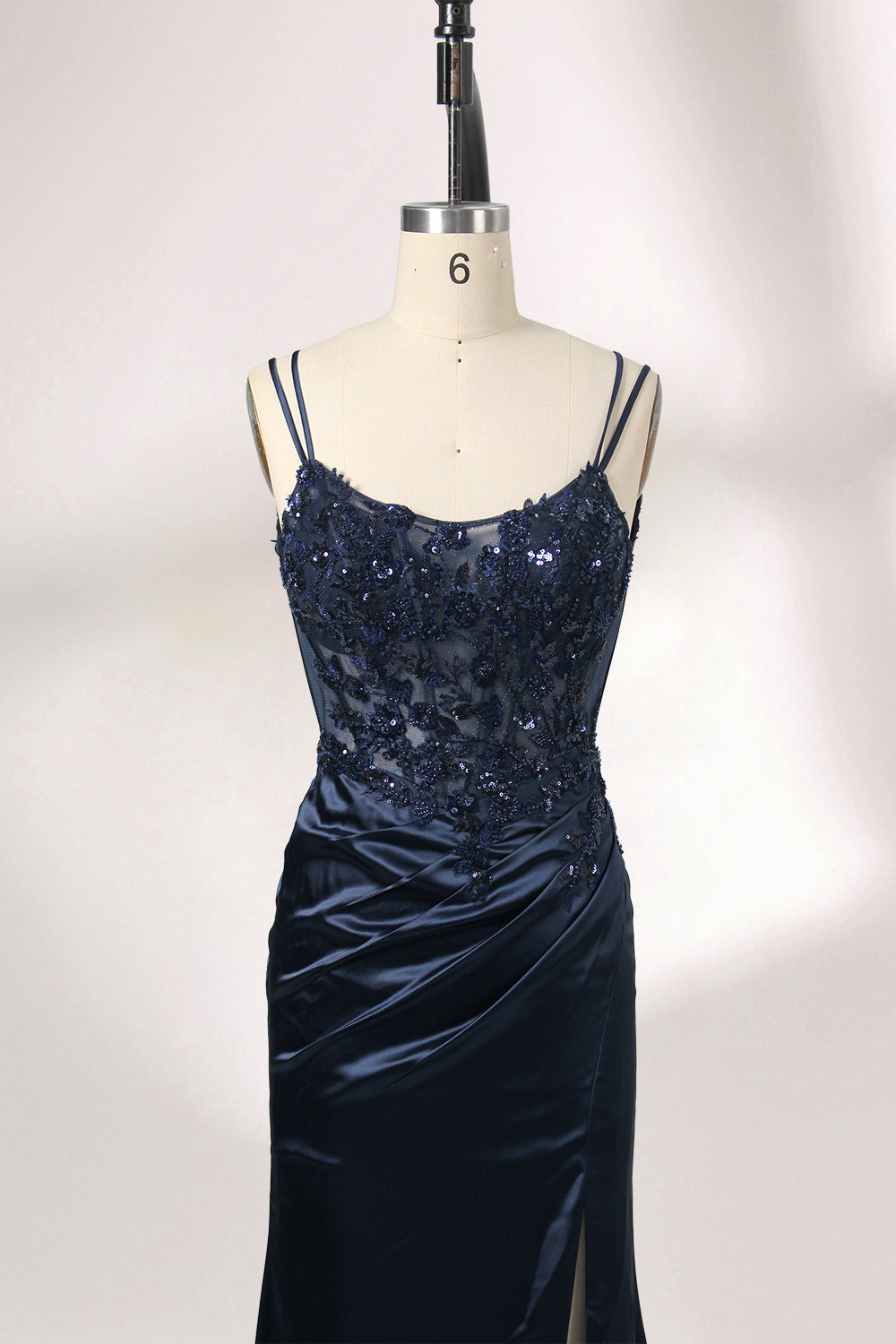 This is a floor - length evening dress in a deep navy hue. It has a strapless style with thin shoulder straps. The bodice is embellished with delicate beadwork and embroidery, creating an elegant and glamorous look. The skirt is form - fitting around the hips and flows down to the floor, featuring a side slit that adds allure and allows for easy movement. Displayed on a mannequin against a simple, light - colored backdrop, the dress exudes sophistication, perfect for special occasions like galas or proms.03