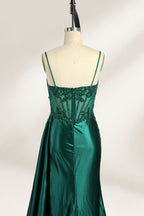 Photograph of an elegant, strapless green satin evening gown on a dress form. The dress features a fitted bodice adorned with intricate beading and lacework, transitioning into a flowing, ruched skirt that cascades to the floor. The gown's deep emerald green color exudes luxury and sophistication. The background is a plain, off-white studio setting, highlighting the dress's opulence. The dress form is positioned centrally, with the dress's front view prominently displayed.3