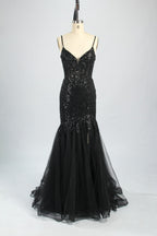 Photograph of a young Asian woman with fair skin and dark hair in a sleek bun, wearing a stunning, floor-length, deep blue evening gown. The gown has a plunging V-neckline, adorned with intricate beading and sequins, and features a sheer overlay with a high slit on one side, revealing a layer of tulle. The background is a soft, neutral gradient, highlighting the gown's elegance. She accessorizes with large, dangling earrings.8