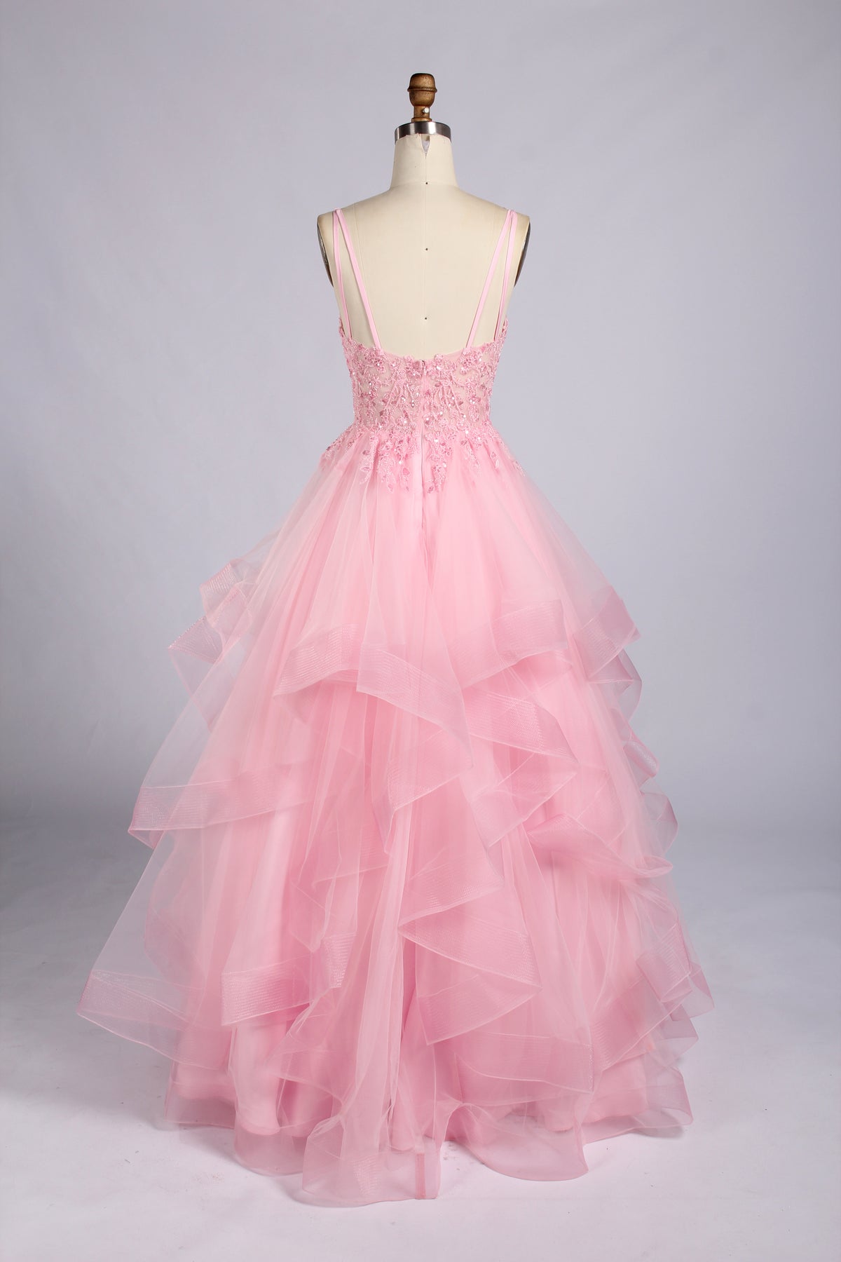 Rear view of pink lace bodice A-line prom dress with spaghetti straps and tulle ruffles