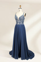 Photograph of a mannequin showcasing an elegant, floor-length evening gown. The gown features a deep V-neckline adorned with intricate blue floral embroidery, transitioning into a flowing, dark blue chiffon skirt. The mannequin stands against a plain, cream-colored backdrop. The dress exudes sophistication and luxury, perfect for formal events.