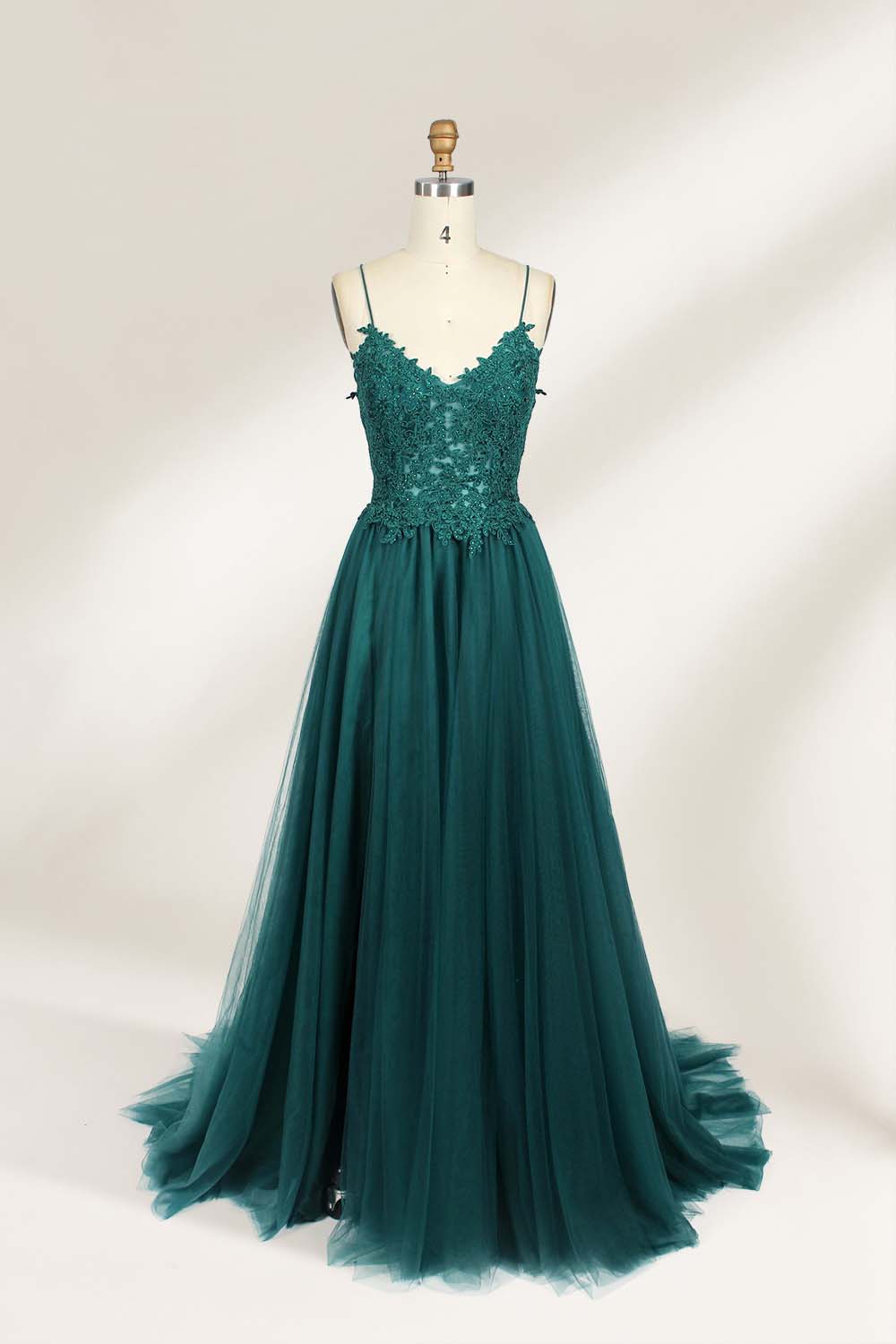 A mannequin showcases a dark - green tulle gown. It has thin spaghetti straps, a lace - detailed bodice, and a voluminous, flowing skirt. The elegant design, with its romantic tulle and delicate lace, suits formal events like galas or weddings.1