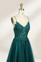 A mannequin showcases a dark - green tulle gown. It has thin spaghetti straps, a lace - detailed bodice, and a voluminous, flowing skirt. The elegant design, with its romantic tulle and delicate lace, suits formal events like galas or weddings.3