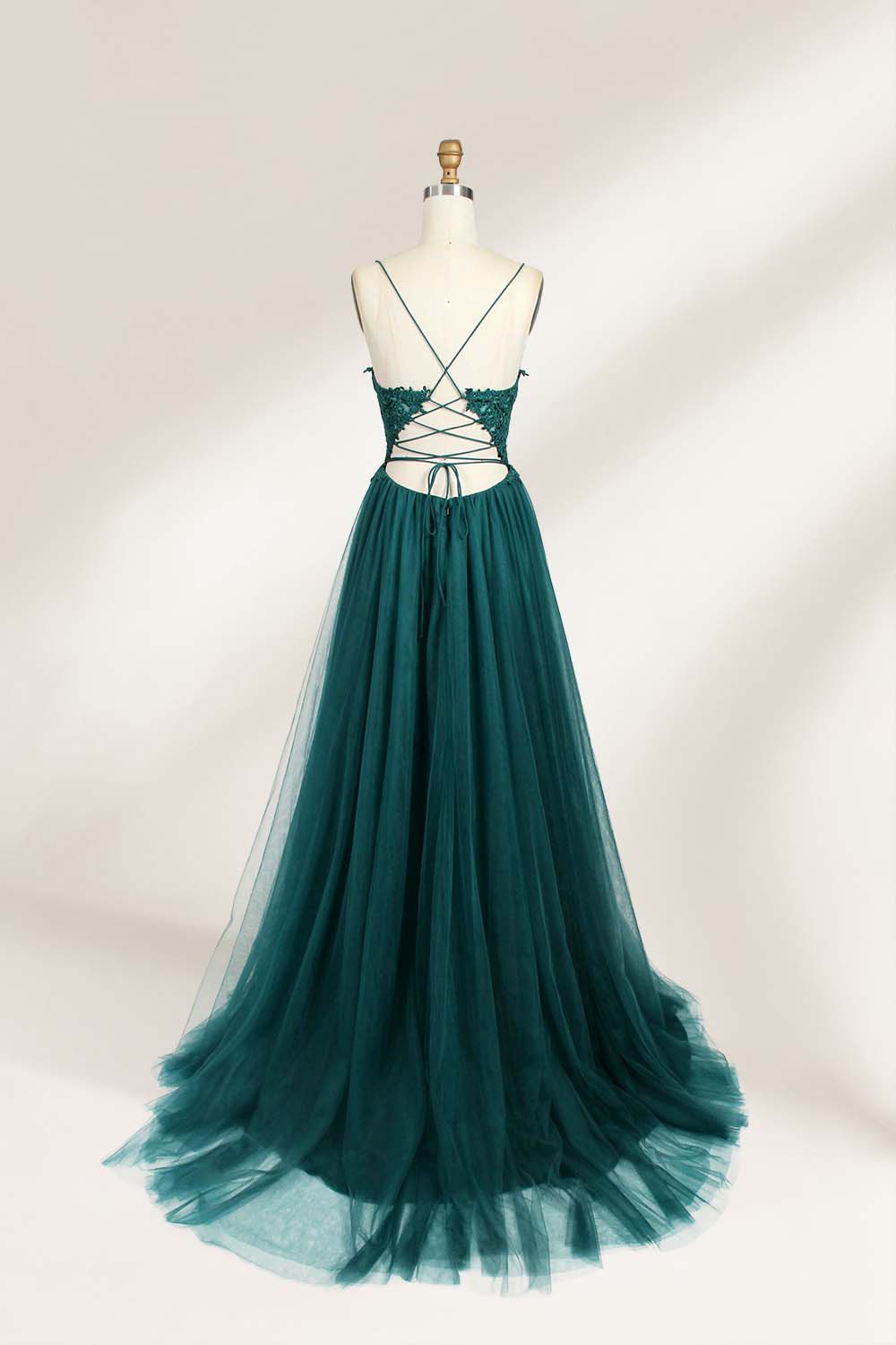 A mannequin showcases a dark - green tulle gown. It has thin spaghetti straps, a lace - detailed bodice, and a voluminous, flowing skirt. The elegant design, with its romantic tulle and delicate lace, suits formal events like galas or weddings.2