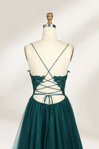 A mannequin showcases a dark - green tulle gown. It has thin spaghetti straps, a lace - detailed bodice, and a voluminous, flowing skirt. The elegant design, with its romantic tulle and delicate lace, suits formal events like galas or weddings.4