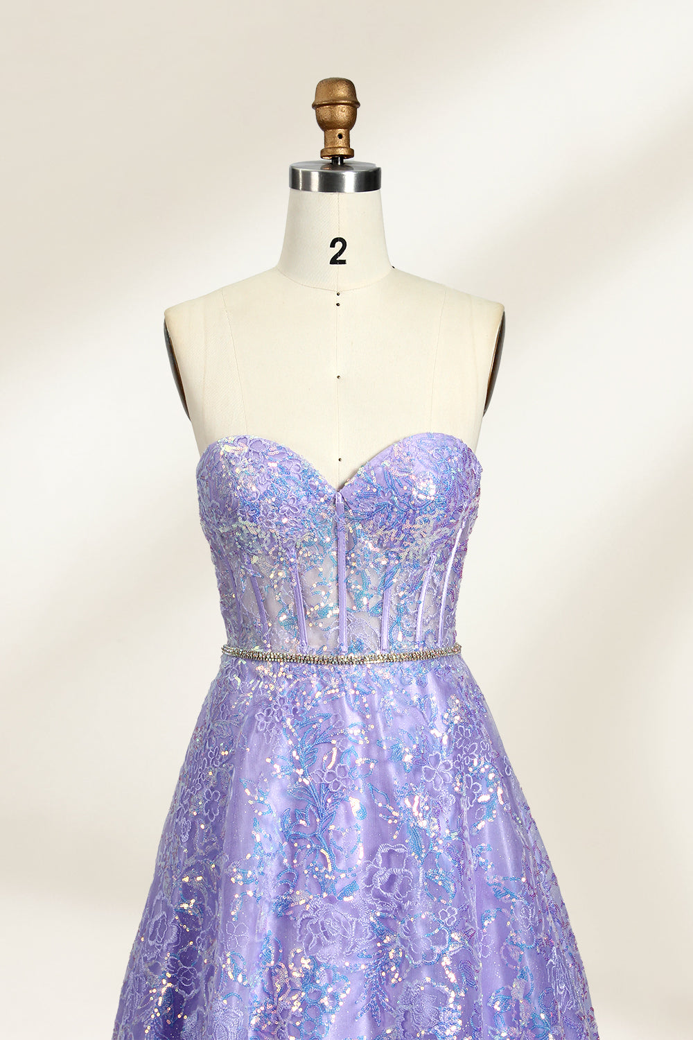 This is a purple evening gown. It has a strapless, sweetheart neckline. The bodice features intricate patterns, cinched at the waist with a thin belt. The floor - length skirt, made of tulle, is covered in iridescent embroidery. Perfect for formal events, it exudes elegance and a dreamy vibe.0