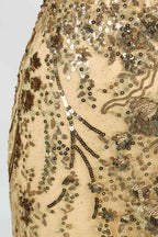 Set against a light background, a woman wears a purple tulle gown embellished with sequin embroidery. It has thin straps, a sweetheart neckline, a sheer bodice patterned with florals, and a mermaid skirt with a high side slit. Silver heels complete the look, with the sparkling sequins and refined silhouette ideal for proms or formal dinners.8