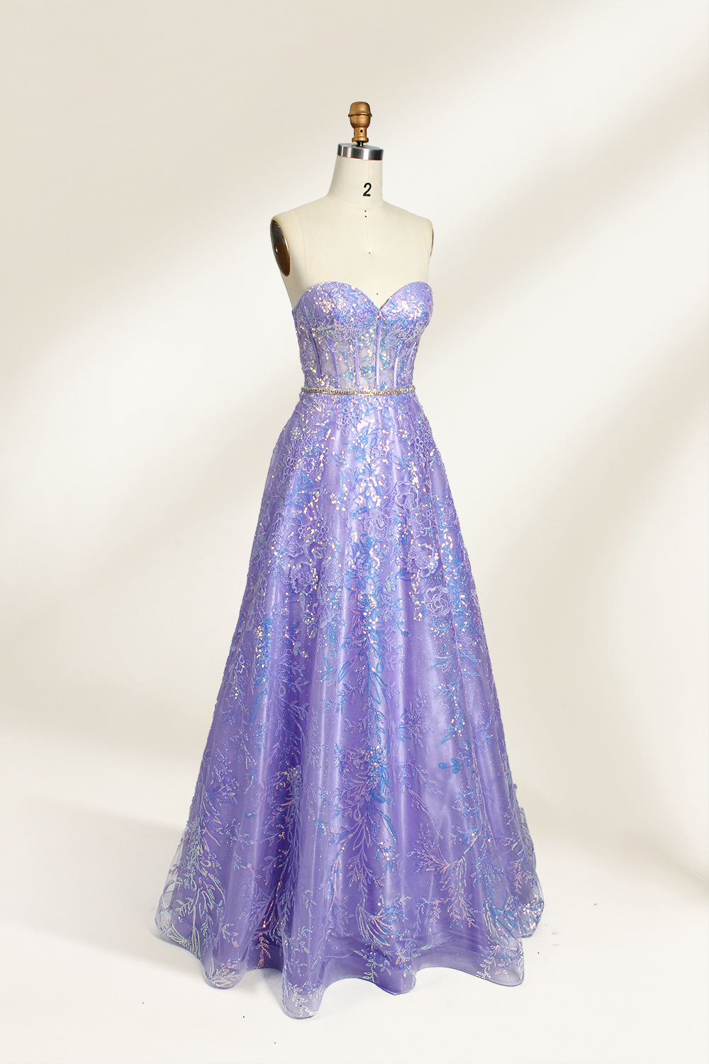 This is a purple evening gown. It has a strapless, sweetheart neckline. The bodice features intricate patterns, cinched at the waist with a thin belt. The floor - length skirt, made of tulle, is covered in iridescent embroidery. Perfect for formal events, it exudes elegance and a dreamy vibe.0