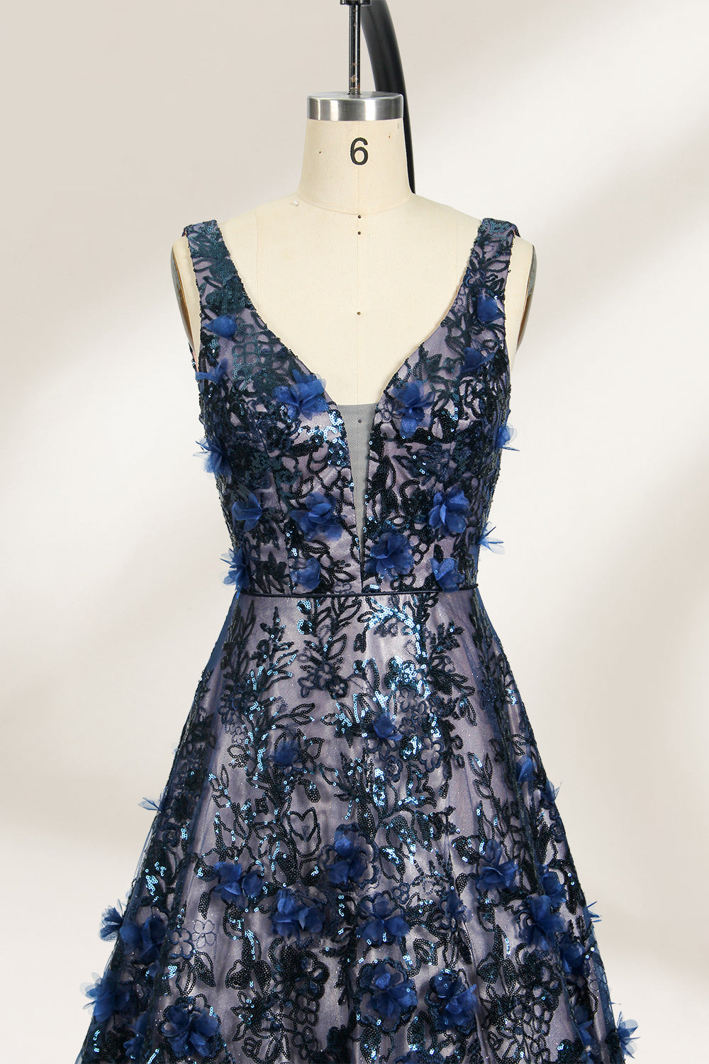 This is an evening gown displayed on a mannequin. It features a deep V - neckline and a sleeveless design. The dress is adorned with numerous blue three - dimensional floral embroideries and black patterns across the bodice and the floor - length skirt. The wide, trailing skirt creates an elegant and formal appearance, making it perfect for occasions such as dinners and balls.03