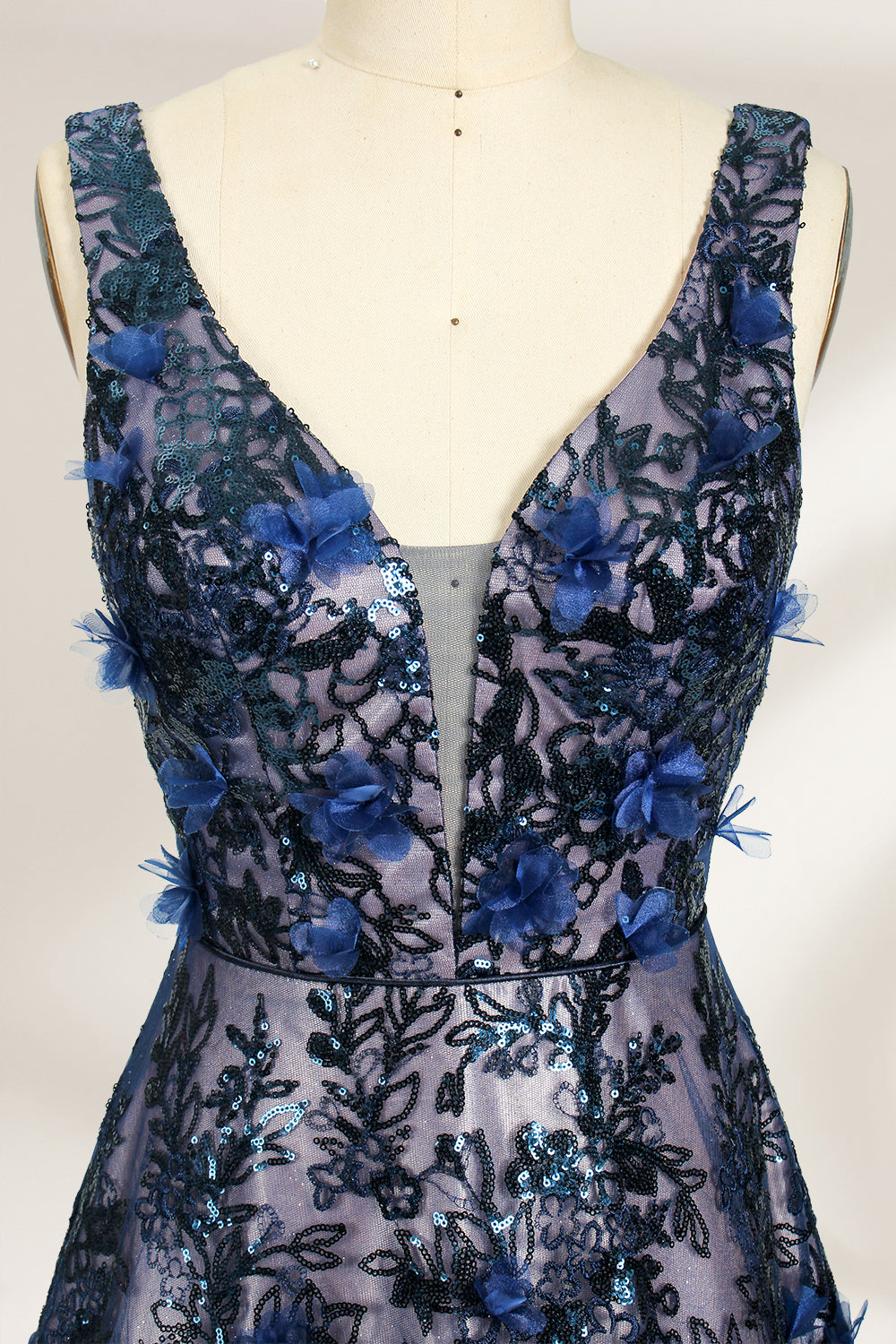 This is an evening gown displayed on a mannequin. It features a deep V - neckline and a sleeveless design. The dress is adorned with numerous blue three - dimensional floral embroideries and black patterns across the bodice and the floor - length skirt. The wide, trailing skirt creates an elegant and formal appearance, making it perfect for occasions such as dinners and balls.05