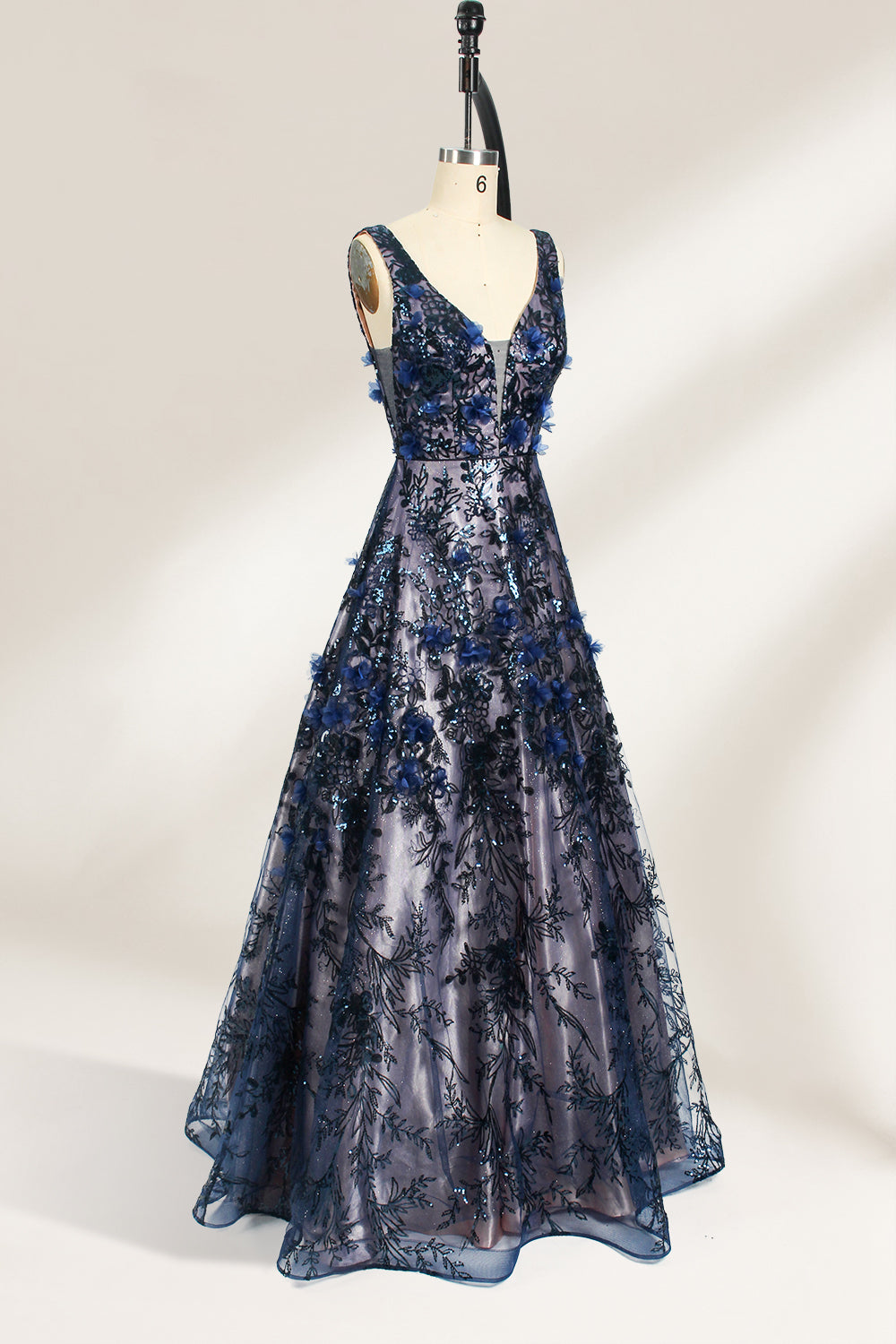 This is an evening gown displayed on a mannequin. It features a deep V - neckline and a sleeveless design. The dress is adorned with numerous blue three - dimensional floral embroideries and black patterns across the bodice and the floor - length skirt. The wide, trailing skirt creates an elegant and formal appearance, making it perfect for occasions such as dinners and balls.04