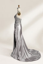 Photograph of a mannequin wearing a stunning, floor-length, navy blue satin evening gown. The gown features a deep V-back with thin straps and intricate sequin detailing along the back and neckline. The fitted bodice gradually flares into a flowing, elegant train. The mannequin stands against a plain, light beige backdrop, highlighting the gown's luxurious texture and shimmering finish. The gown exudes sophistication and glamour, ideal for formal events.5