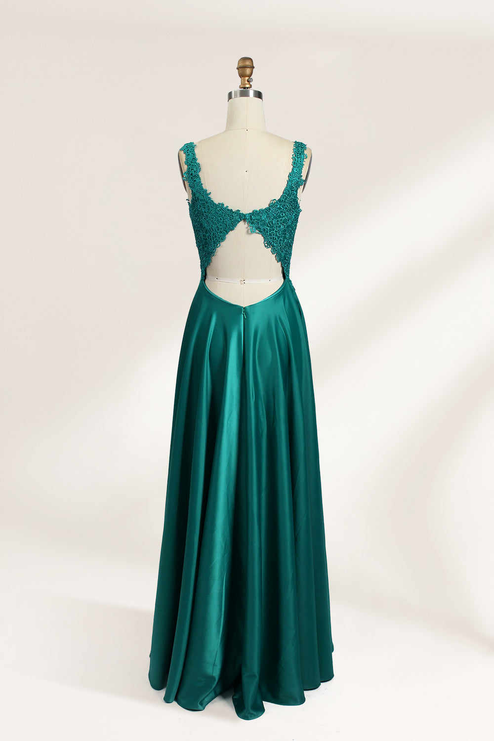 Photograph of a mannequin showcasing a teal, floor-length evening gown with a lace bodice and V-neckline. The gown features a fitted waist and a full, flowing skirt. The mannequin is set against a plain, light-colored background, highlighting the dress's elegant and luxurious design.02