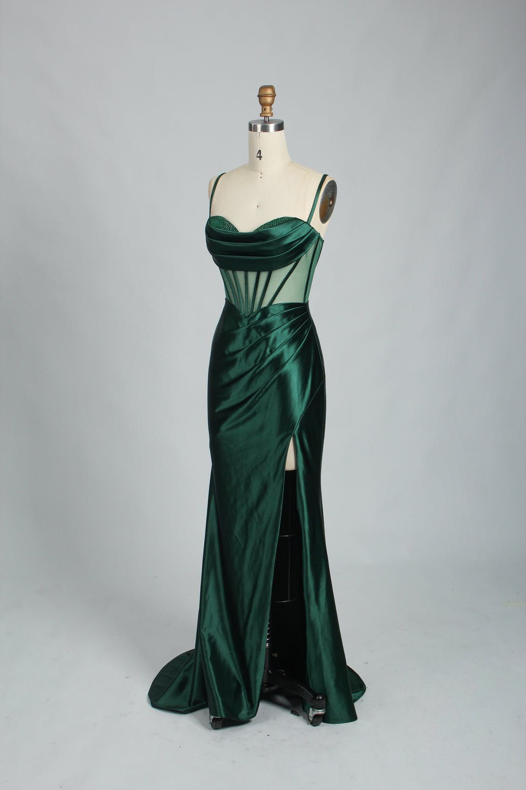 Green satin prom dress with sheer corset bodice, side slit & drape. Luxe, eye-catching design—perfect for bulk orders in premium formal collections.