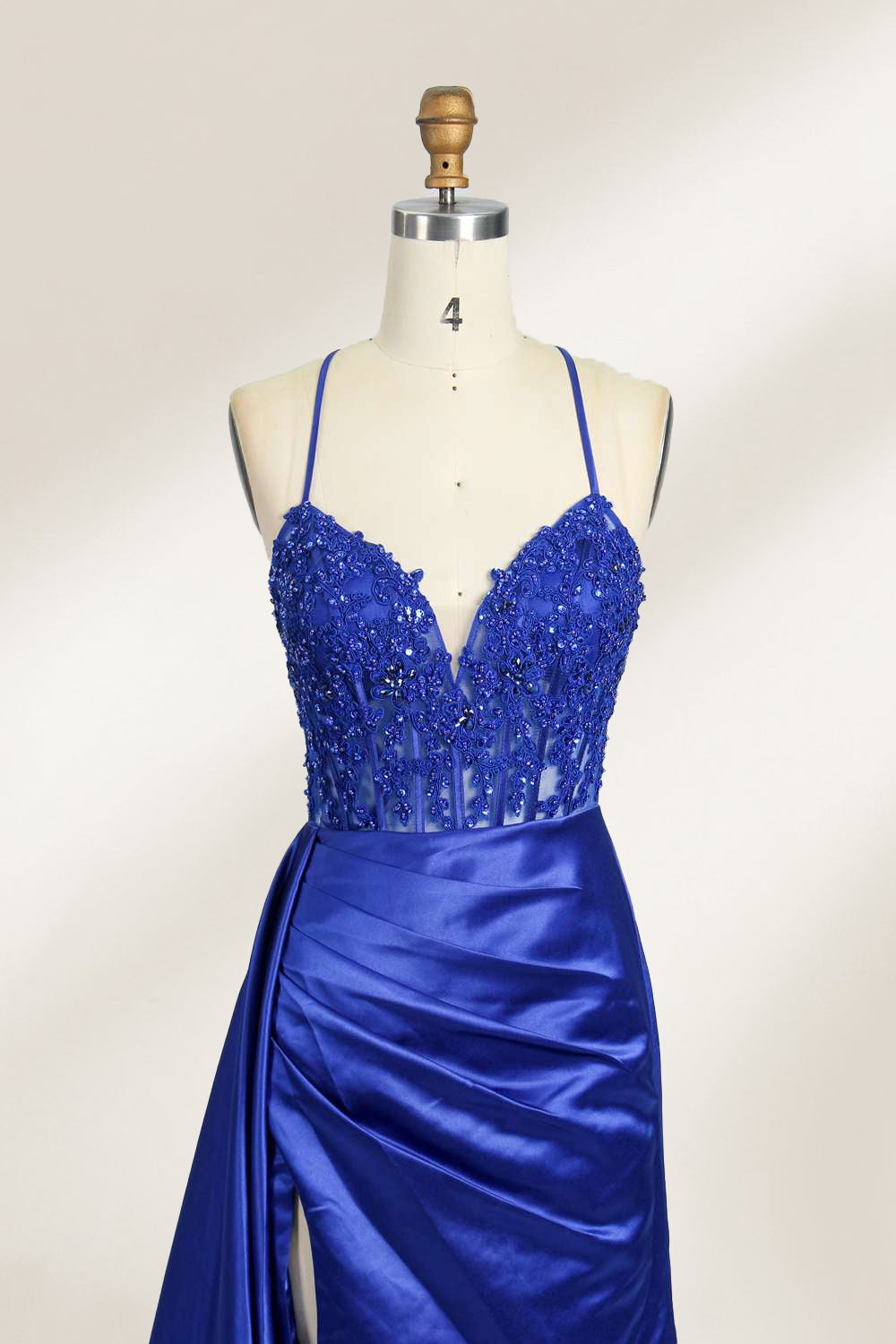 A mannequin showcases a royal - blue gown with thin straps. The bodice features intricate bead embroidery and sheer panels, while the skirt has a ruched design and a high side slit. The satin fabric and elegant details make it perfect for formal events like proms or galas, exuding sophistication.14