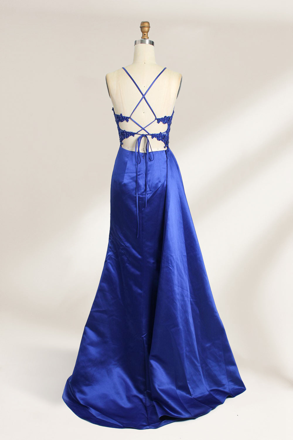 A mannequin showcases a royal - blue gown with thin straps. The bodice features intricate bead embroidery and sheer panels, while the skirt has a ruched design and a high side slit. The satin fabric and elegant details make it perfect for formal events like proms or galas, exuding sophistication.2
