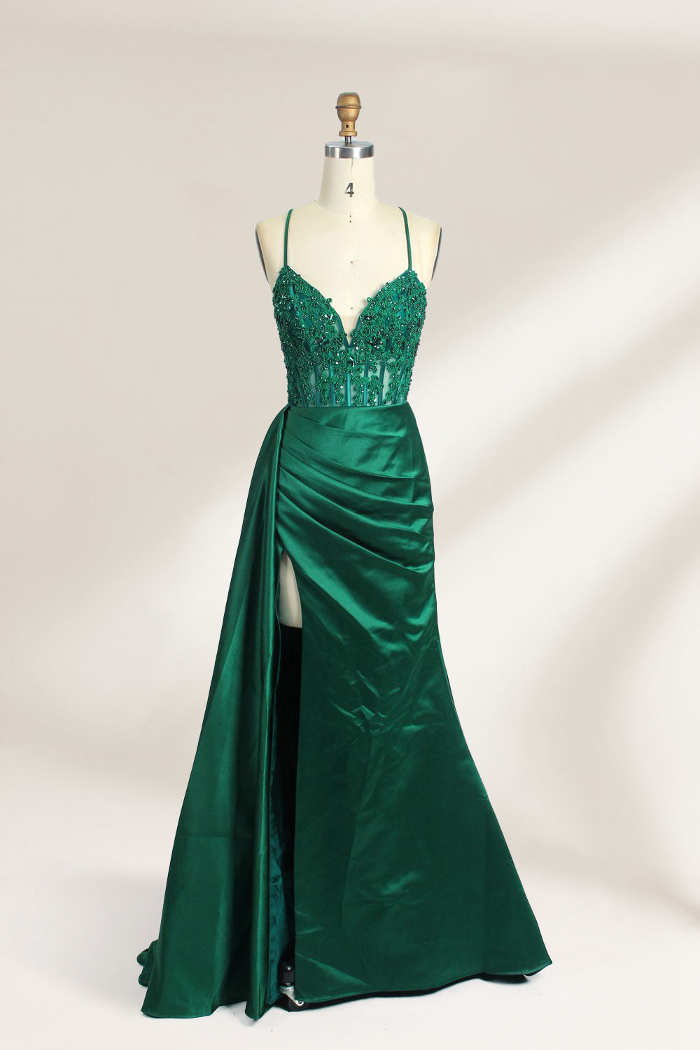 A mannequin showcases a royal - blue gown with thin straps. The bodice features intricate bead embroidery and sheer panels, while the skirt has a ruched design and a high side slit. The satin fabric and elegant details make it perfect for formal events like proms or galas, exuding sophistication.1