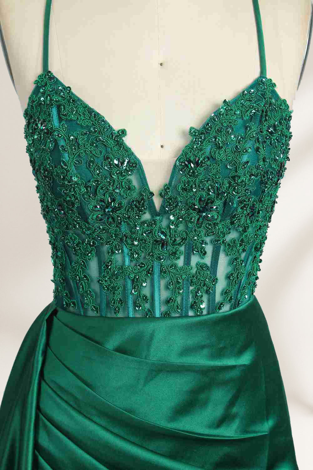 A mannequin showcases a royal - blue gown with thin straps. The bodice features intricate bead embroidery and sheer panels, while the skirt has a ruched design and a high side slit. The satin fabric and elegant details make it perfect for formal events like proms or galas, exuding sophistication.4