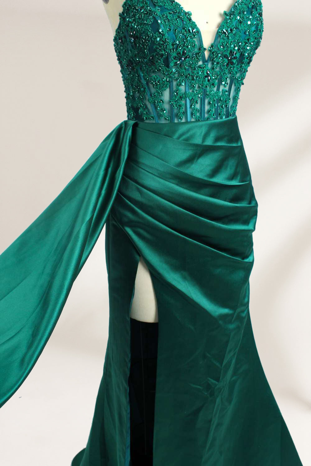 A mannequin showcases a royal - blue gown with thin straps. The bodice features intricate bead embroidery and sheer panels, while the skirt has a ruched design and a high side slit. The satin fabric and elegant details make it perfect for formal events like proms or galas, exuding sophistication.9