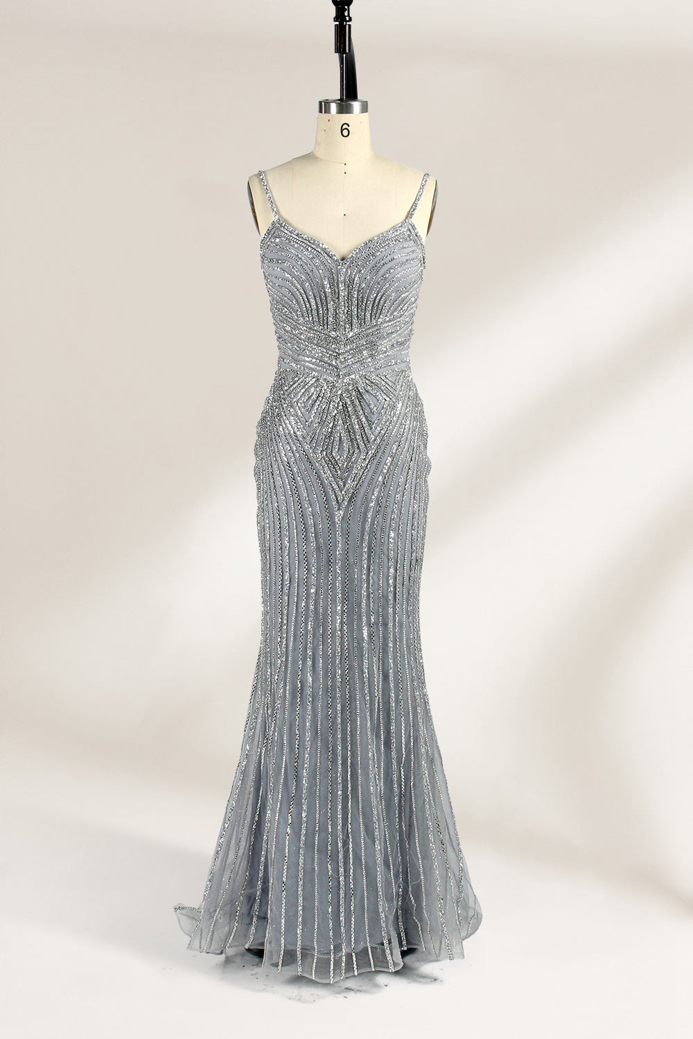 Set against a light background, a mannequin presents a grey tulle gown. It has thin straps, a sweetheart neckline, and a mermaid - shaped skirt. The detailed silver bead embroidery creates an elegant pattern, making it ideal for formal events like proms, radiating sophistication.1