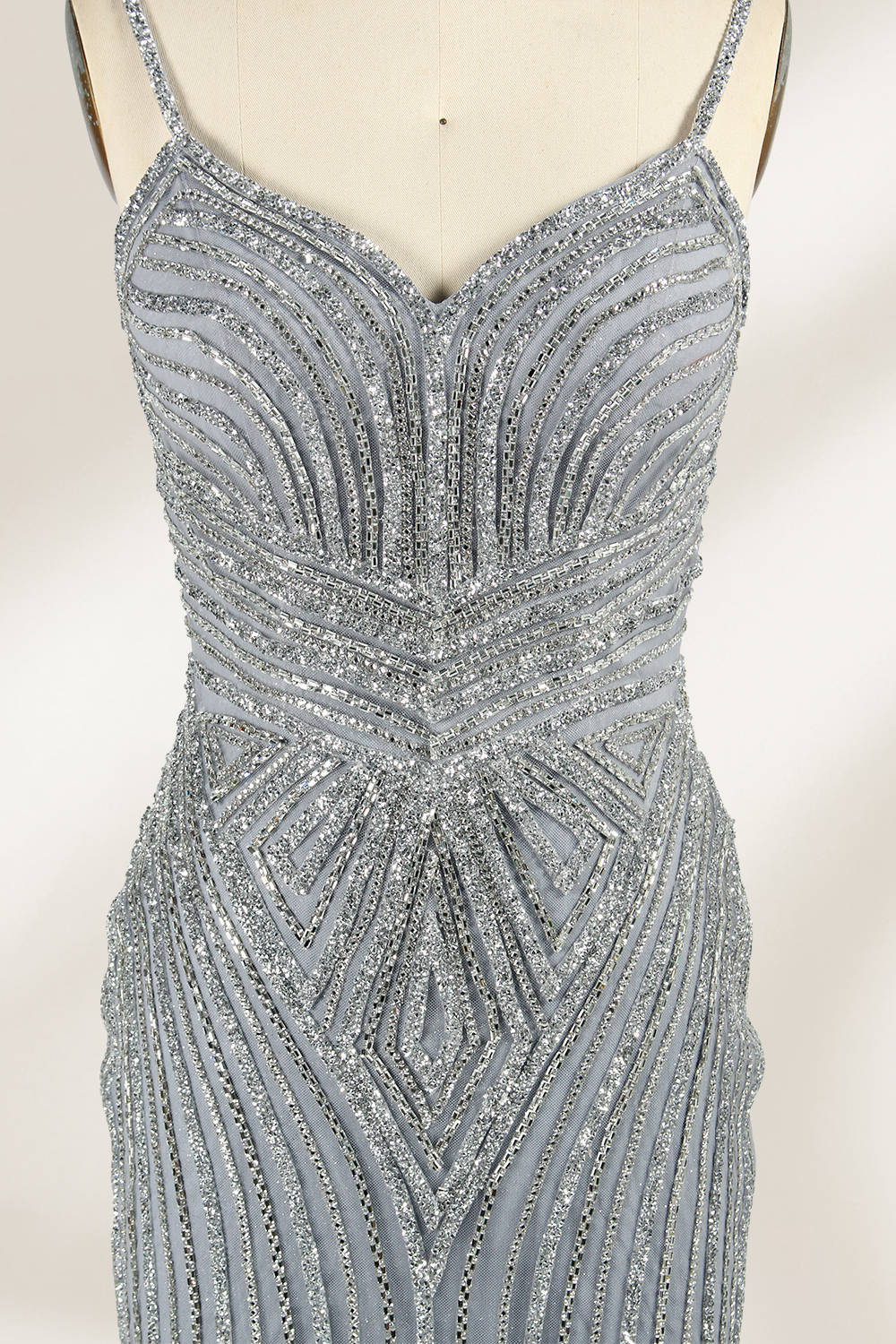 Set against a light background, a mannequin presents a grey tulle gown. It has thin straps, a sweetheart neckline, and a mermaid - shaped skirt. The detailed silver bead embroidery creates an elegant pattern, making it ideal for formal events like proms, radiating sophistication.3