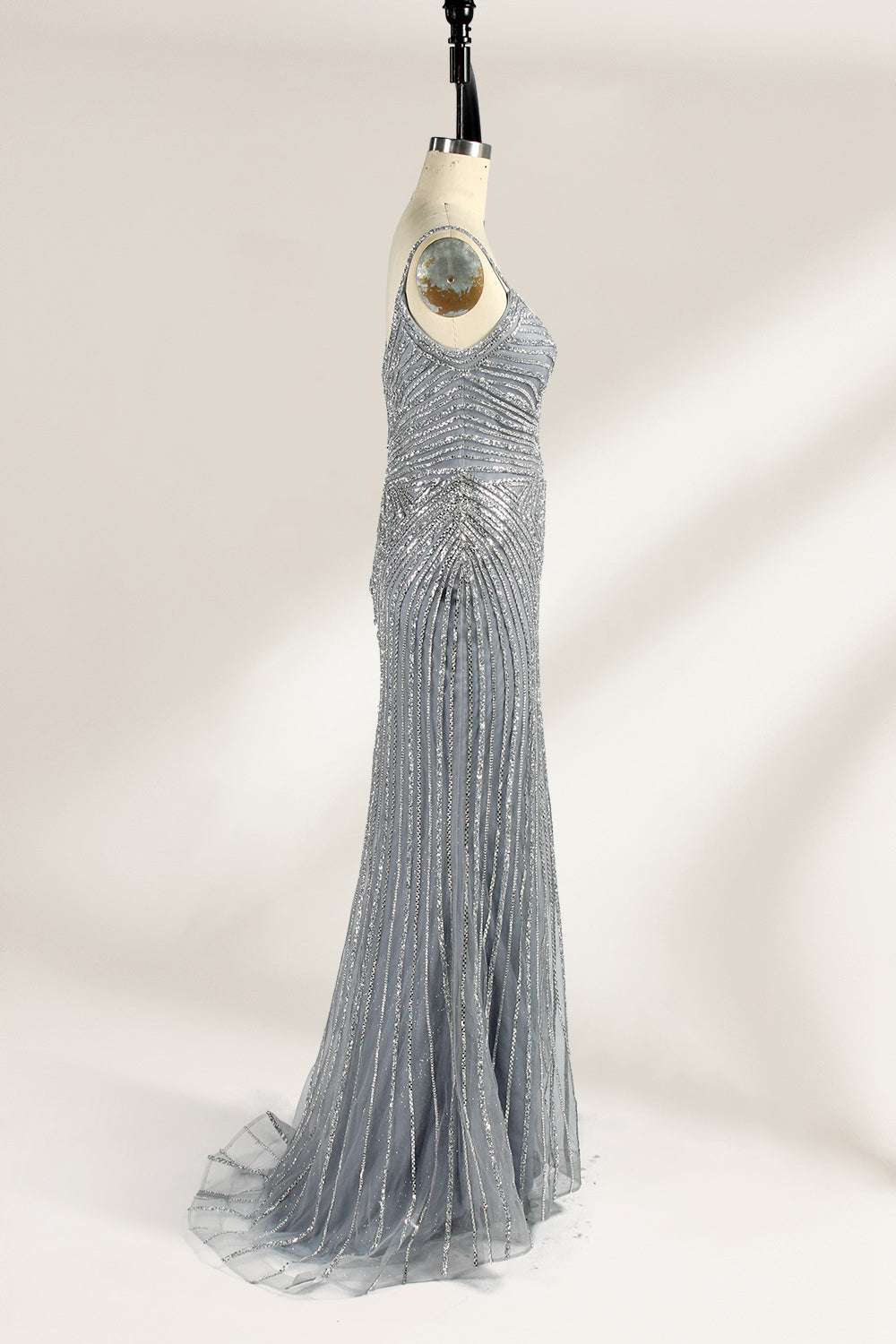 Set against a light background, a mannequin presents a grey tulle gown. It has thin straps, a sweetheart neckline, and a mermaid - shaped skirt. The detailed silver bead embroidery creates an elegant pattern, making it ideal for formal events like proms, radiating sophistication.5