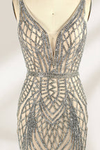 Against a light - hued backdrop, a mannequin displays a nude - toned tulle gown featuring silver beaded embellishments. It has thin straps, a deep V - neckline, and a mermaid - shaped skirt. The detailed beadwork weaves sophistication, perfect for formal dinners or weddings, where the beaded elegance complements the occasion.6