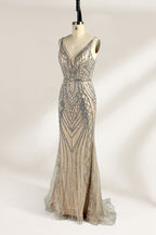 Against a light - hued backdrop, a mannequin displays a nude - toned tulle gown featuring silver beaded embellishments. It has thin straps, a deep V - neckline, and a mermaid - shaped skirt. The detailed beadwork weaves sophistication, perfect for formal dinners or weddings, where the beaded elegance complements the occasion.4